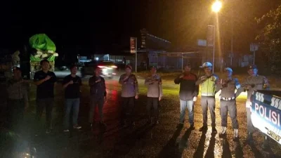 "Personel Polres Sekadau saat memberikan imbauan kepada sopir truk di pinggir jalan utama guna memastikan kelancaran lalu lintas dan mencegah balap liar, Sabtu (14/2/2026) malam."
