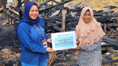 Pegawai Bank Kalbar saat menyerahkan bantuan kepada Ibu Zainab, guru ngaji yang rumahnya terbakar di Desa Penakalan, Kecamatan Sejangkung, Kabupaten Sambas. (Foto: HO/Faktakalbar.id)
