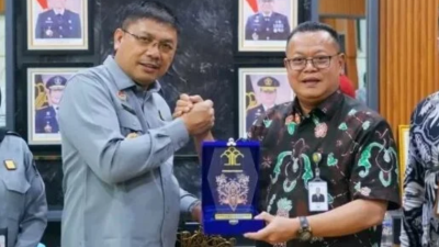 Kepala Kantor Wilayah Kemenkumham Kalbar, Jonny Pesta Simamora (kedua dari kanan), menerima cendera mata dari Direktur Utama Bank Kalbar, Rokidi (kedua dari kiri). (Dok. KANWIL KEMENKUM Kalbar)