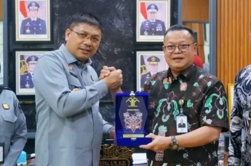 Kepala Kantor Wilayah Kemenkumham Kalbar, Jonny Pesta Simamora (kedua dari kanan), menerima cendera mata dari Direktur Utama Bank Kalbar, Rokidi (kedua dari kiri). (Dok. KANWIL KEMENKUM Kalbar)