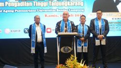 Ketua Divisi Seminar IKA FH Unila, Sukarmin (berdiri di podium) dalam kegiatan tahapan pelantikan dan pembekalan yang digelar DPN PERADI di Mahligai Universitas Bandar Lampung. (FAKTANASIONAL/HO).
